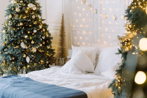 Stylowe wnętrze świąteczne z miękkim łóżkiem. Dom pocieszenia. Choinka z prezentami pod spodem w salonie — Zdjęcie stockowe