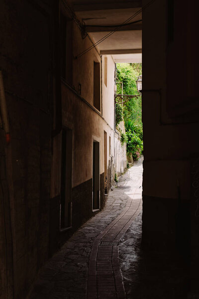 The dark arch in the Italian house. Typical Italian narrow street. Patio in the city