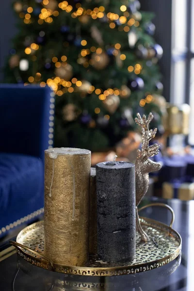 Dwie świece w kształcie cylindra na tle świątecznych świateł na choince — Zdjęcie stockowe