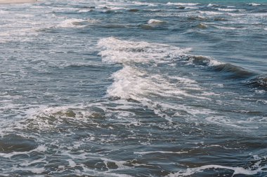 İtalya 'daki Akdeniz' de küçük bir dalga. Baharda küçük soğuk deniz dalgaları üzerinde beyaz ışık köpüğü.