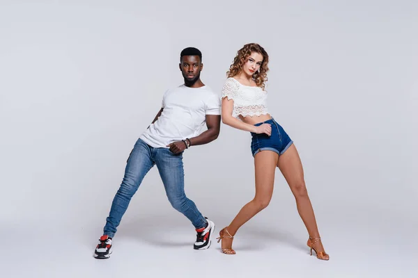 Couple dancers posing over white background. Man and woman are dancing, dance costumes. International dance group. Dancers dance. Passionate original variety of pair of dancers. Fitness concept