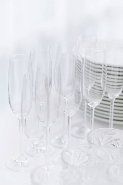 Clean champagne glasses made of clear glass. Clean and empty dishes in the restaurant. Selective focus