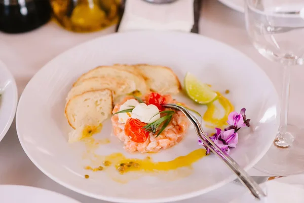 Cocina mediterránea. Mariscos y rebanadas secas de pan en un plato blanco en el restaurante. Volar en ensalada, fuerza mayor del restaurante — Foto de Stock