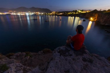 Uçurumun kenarındaki adam uzaklığa bakıyor.