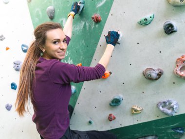 Duvardaki kaya spor salonuna tırmanan bir kadın..