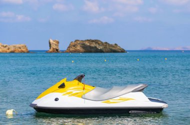 Mavi deniz ve denizde yüzen bir jet ski. Girit