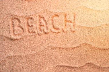 Kumsalda dalgalı ve akşam güneşli harfler var. Minimum egzotik tatil ve seyahat konsepti, düz görünüm kopyalama alanı