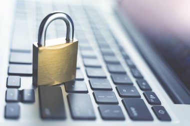 Bilgisayar güvenliği kavramı. Laptop klavyesine kilitlenmiş asma kilit. Kasanın sembolü. Yumuşak odaklı tonlu resim.