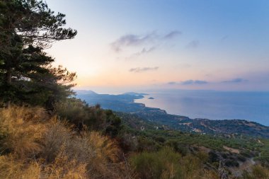 Girit adası plajı ve gün batımında dağlar. Yunanistan tatili.