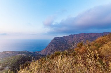 Girit adası plajı ve gün batımında dağlar. Yunanistan tatili.