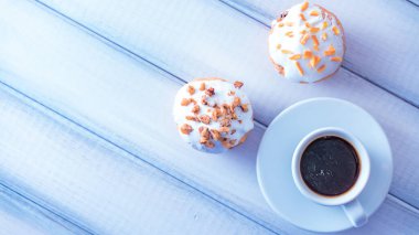 Beyaz ahşap masada çöreklerle sabah kahvesi. Boşluğu kopyala.