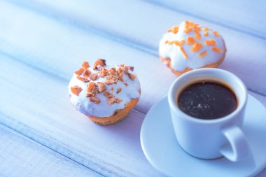 Beyaz ahşap masada çöreklerle sabah kahvesi. Kapat..