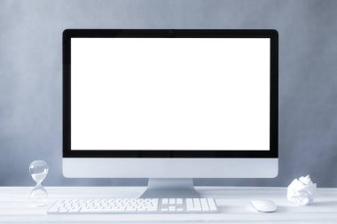 Bilgisayar tek bir modelde, ev ve ofis çalışma alanı kavramında. Çalışma masasının ön görünümünde bilgisayar beyaz ekranı. Boşluğu kopyala
