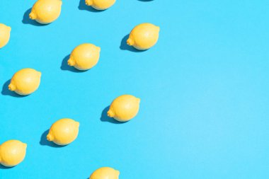 Minimum besin dokusu yatıyordu. Yaz soyut moda taze konsept. Parlak açık mavi arkaplanda limon deseni, boşluğu kopyala.