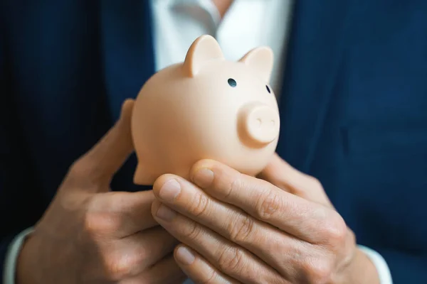 Money Protecting concept. Saving symbol - Close-up Of A Human Hand keeps Pink Piggy Bank