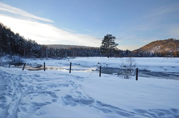 Paisaje invernal con un arroyo y costas nevadas — Foto de Stock