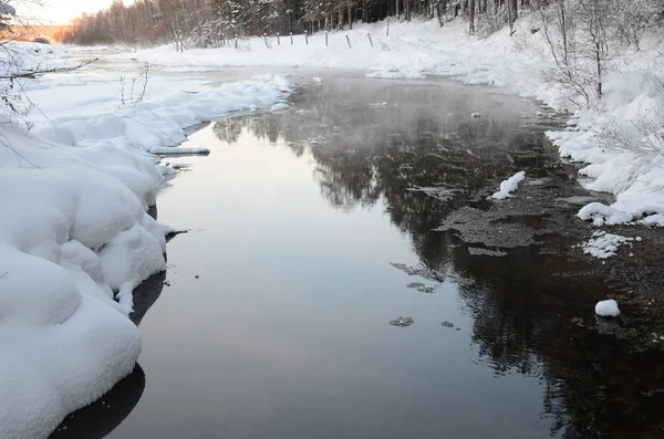 Paisaje invernal con un arroyo y costas nevadas — Foto de Stock