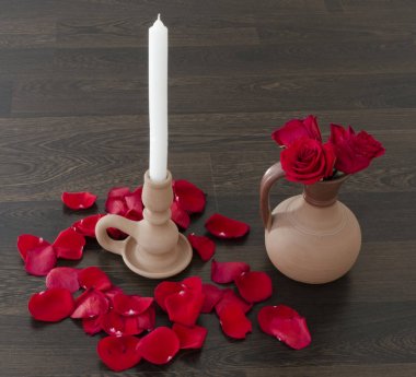Gül yaprakları ve kırmızı gül ile sürahi beyaz mum ile el yapımı kil şamdan