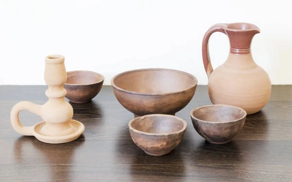 Clay handmade bowls, candlestick and milk jug — Stock Photo, Image