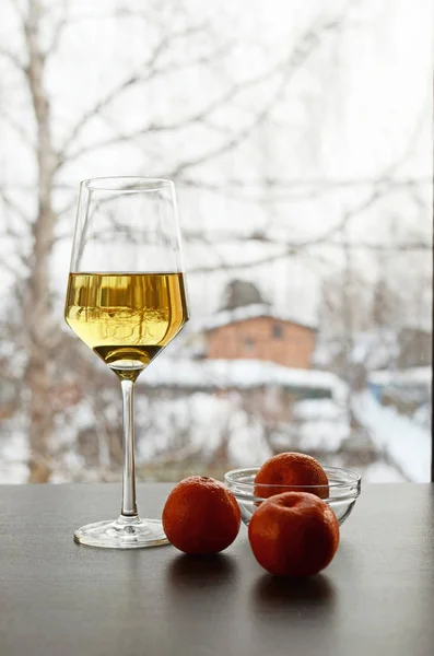 Glas witte wijn drie mandarijnen op winter achtergrond Stockafbeelding