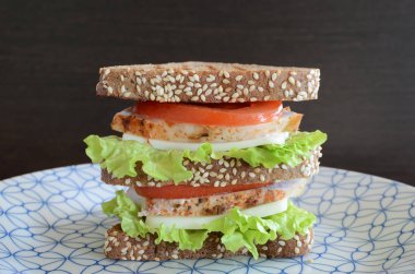 Üçgen ekmek tavuk sandviç domates meme ve siyah arka plan peynir