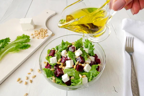 Salată sfeclă roșie, brânză feta și frunze de salată cu nuci de pin turnate ulei de măsline — Fotografie, imagine de stoc