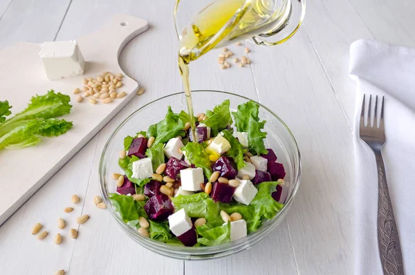 Salată sfeclă roșie, brânză feta și frunze de salată cu nuci de pin turnate ulei de măsline — Fotografie, imagine de stoc