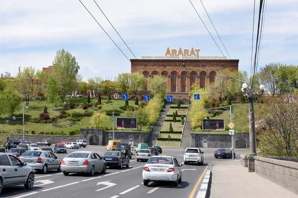 Ερεβάν, Αρμενία-Απρίλιος, 28 2019: δρόμος πάνω από τη Γέφυρα της Νίκης και πρόσοψη του Εργοστασίου Ερεβάν Μπράντυ, της κορυφαίας εταιρείας αλκοολούχων ποτών της Αρμενίας — Φωτογραφία Αρχείου