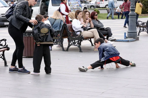 Erivan, Ermenistan-Nisan, 28 2019: Erivan meydanında sicim üzerinde oturan çocuk — Stok fotoğraf