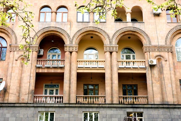 Frammento di edificio con piccoli balconi con archi, colonne e sculture in pietra. Erevan, Armenia — Foto Stock