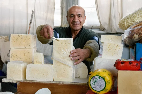 Ereván, Armenia-abril, 29 2019: Vendedor en el mercado de comestibles en Ereván corta queso para probar — Foto de Stock