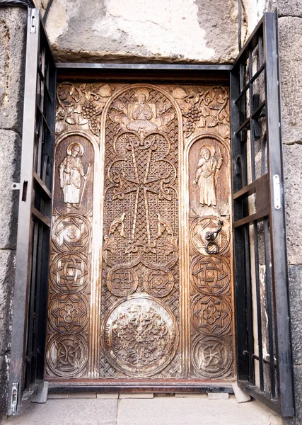 La península de Sevan. Armenia-May, 01 2019: Puerta de madera tallada de Sourp Arakelots, Monasterio de Sevanavank, Armenia —  Fotos de Stock