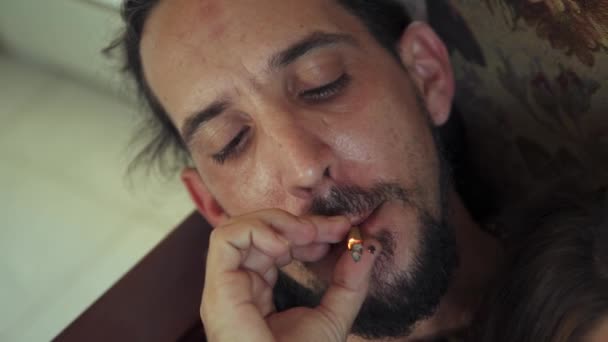 Junger Mann und Frau rauchen zu Hause Marihuana-Zigarette