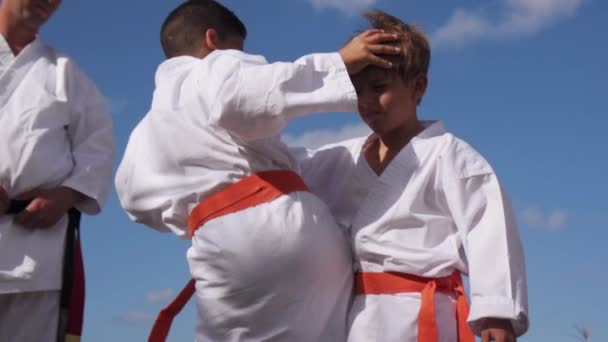 Niños luchando en la escuela de karate con el profesor de cámara lenta — Vídeo de stock