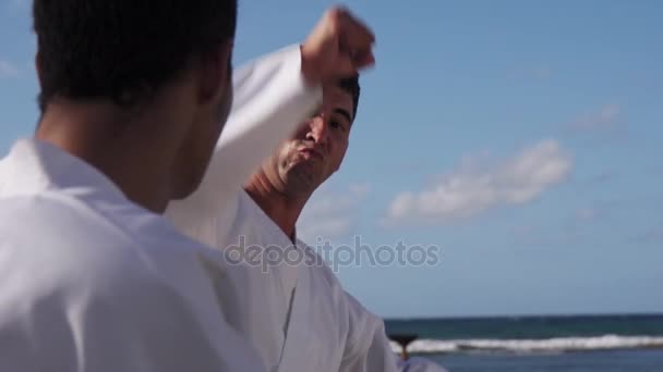 Hombre fuerte pateando y luchando en la playa cerca del mar — Vídeo de stock