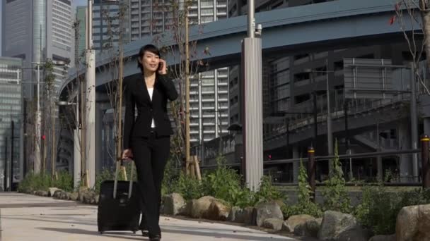 Ralenti mouvement asiatique femme d'affaires parler sur téléphone voyager avec bagages — Video