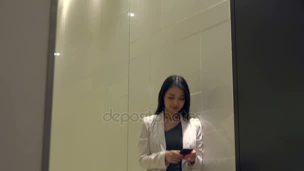 Ofis binası içinde cep telefonuyla konuşurken çekici Asyalı kadın — Stok video