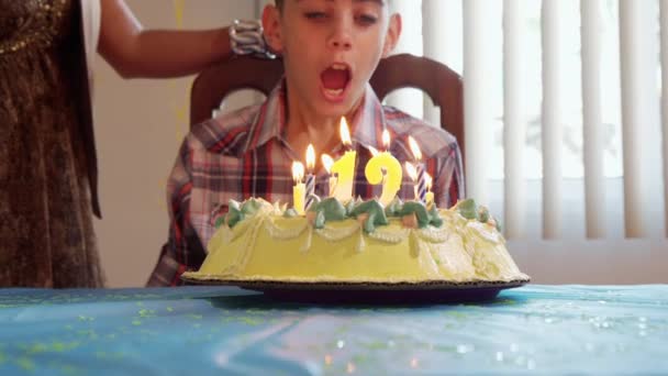Geburtstagsparty mit fröhlichem Latino-Boy, der Kerzen auf Kuchen pustet