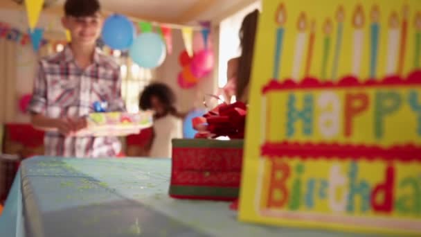 Barn att sätta närvarande på bordet under födelsedagsfest hemma — Stockvideo