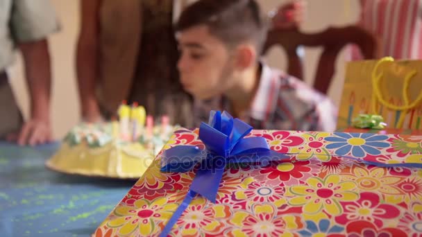 Вечеринка с счастливым латиноамериканским ребенком, дующим свечами на торт — стоковое видео