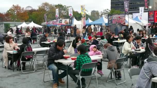 Японцы едят традиционную азиатскую еду на ярмарке в Хиросиме — стоковое видео