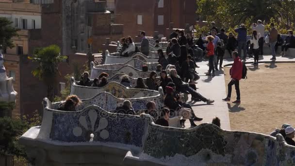 Amplia gente de tiro sentado en el banco en el Parc Güell Barcelona — Vídeos de Stock