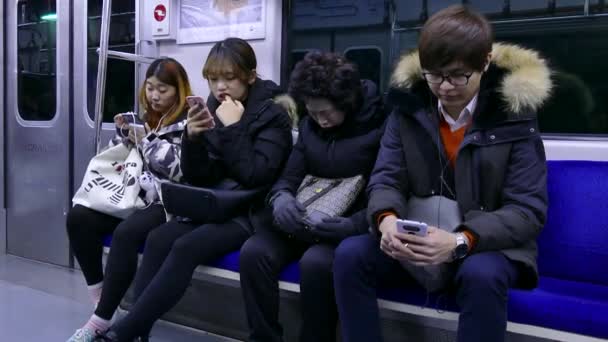 Jovens com telefone celular Smartphone no metrô de Seul — Vídeo de Stock