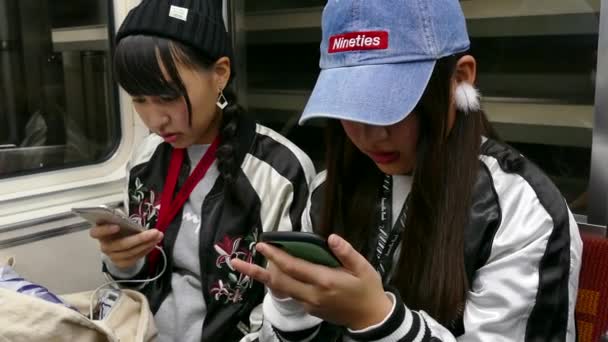 วัยรุ่นใช้สมาร์ทโฟนบนรถไฟใต้ดินในโอซาก้าญี่ปุ่นเอเชีย — วีดีโอสต็อก