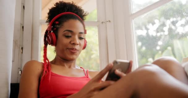 Chica escuchando música con auriculares rojos y cantando — Vídeos de Stock