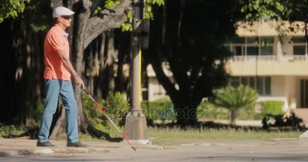 Slepý člověk přes ulici a chodí s holí — Stock video
