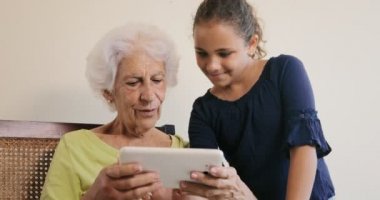 Büyükanne torunu tarafından kullanılan Internet için tablet Ipad bilgisayar teknolojisi