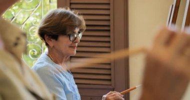 Yaşlı kadın onun hobi resim resim dersinde pratik