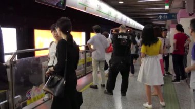 Shanghai Çin metro istasyonunda metro treninin için bekleyenler