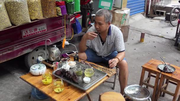 Китайська людина виступає і продавати чай на ринок Китаю Guilin — стокове відео